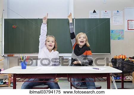"Two schoolgirls, 7 and 9 years, putting up their hands in class" View Large Photo Image Stock Photography - "Two schoolgirls, 7 and 9 years, putting up their hands in class". Fotosearch
