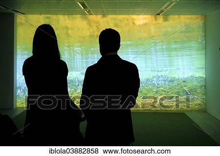 Stock Photo - "Two silhouetted visitors in a gallery looking at a light installation, Frankfurt am Main, Hesse, Germany, Europe". Fotosearch