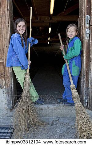 Picture - "Two sisters holding stable brooms, Alp Gun, Graubunden, Switzerland, Europe". Fotosearch