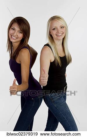 Two smiling young women making thumbs up gesture View Large Photo Image Stock Photo - Two smiling young women making thumbs up gesture. Fotosearch