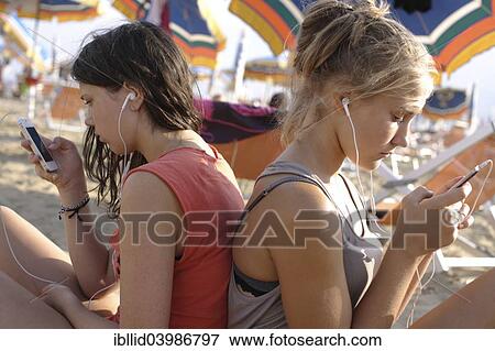 "Two teenage girls, 13 years, with mobile phones at the beach" View Large Photo Image Stock Photo - "Two teenage girls, 13 years, with mobile phones at the beach". Fotosearch