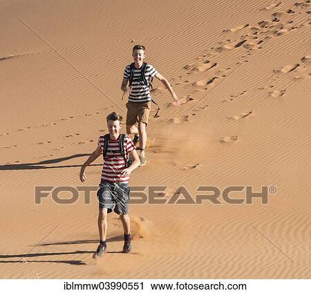 "Two teens running down a dune, Sossusvlei, Namib Desert, Namibia, Africa" View Large Photo Image Stock Image - "Two teens running down a dune, Sossusvlei, Namib Desert, Namibia, Africa". Fotosearch