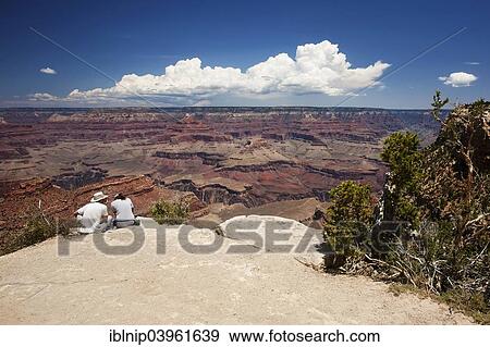 "Two tourists sitting at the South Rim of Grand Canyon, Arizona, USA" View Large Photo Image Stock Photo - "Two tourists sitting at the South Rim of Grand Canyon, Arizona, USA". Fotosearch