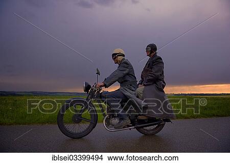 "Two vintage motorcyclists in front of a dramatic cloudy sky, Mindelheim, Unterallgau District, Bavaria, Germany, Europe" View Large Photo Image Picture - "Two vintage motorcyclists in front of a dramatic cloudy sky, Mindelheim, Unterallgau District, Bavaria, Germany, Europe". Fotosearch