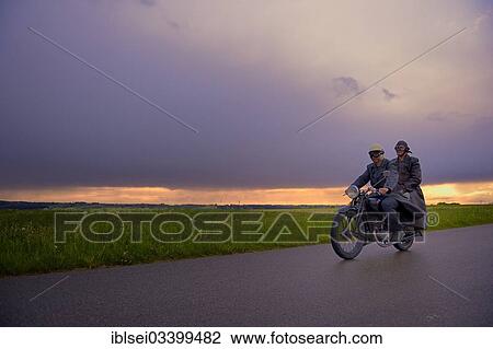 "Two vintage motorcyclists in front of a dramatic cloudy sky, Mindelheim, Unterallgau District, Bavaria, Germany, Europe" View Large Photo Image Stock Image - "Two vintage motorcyclists in front of a dramatic cloudy sky, Mindelheim, Unterallgau District, Bavaria, Germany, Europe". Fotosearch