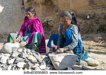 Stock Image - "Two women cutting stones with a hammer, Kathmandu Valley, Kathmandu, Kathmandu District, Bagmati Zone, Nepal, Asia". Fotosearch