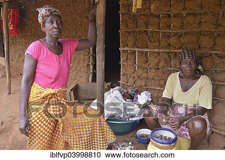 "Two women in front of her mud hut, baby lying in a bowl between them, near Kent, Western Peninsula, Sierra Leone, Africa" View Large Photo Image Stock Image - "Two women in front of her mud hut, baby lying in a bowl between them, near Kent, Western Peninsula, Sierra Leone, Africa". Fotosearch