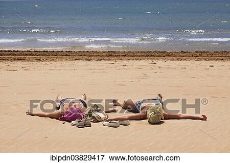 "Two women with covered heads sunbathing on the beach, Salou, Catalonia, Spain, Europe" View Large Photo Image Stock Photo - "Two women with covered heads sunbathing on the beach, Salou, Catalonia, Spain, Europe". Fotosearch