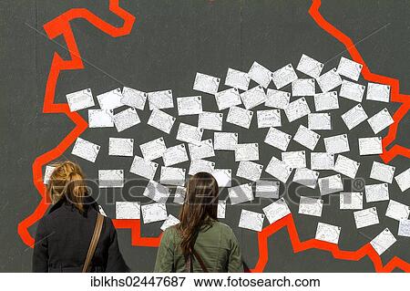 "Two young female tourists standing in front of a wall with postcards, display set up for the 775th anniversary celebrations of the city of Berlin, at the old Schlossplatz square, Berlin-Mitte, Berlin, Germany, Europe" View Large Photo Image Stock Photo - "Two young female tourists standing in front of a wall with postcards, display set up for the 775th anniversary celebrations of the city of Berlin, at the old Schlossplatz square, Berlin-Mitte, Berlin, Germany, Europe". Fotosearch
