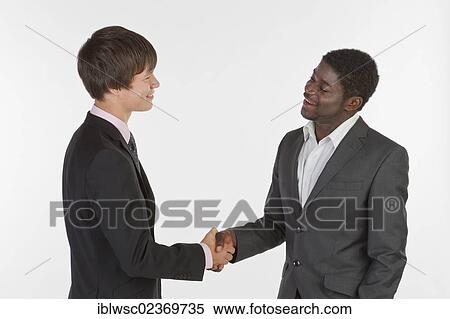 Two young men of different races shaking hands View Large Photo Image Stock Photography - Two young men of different races shaking hands. Fotosearch