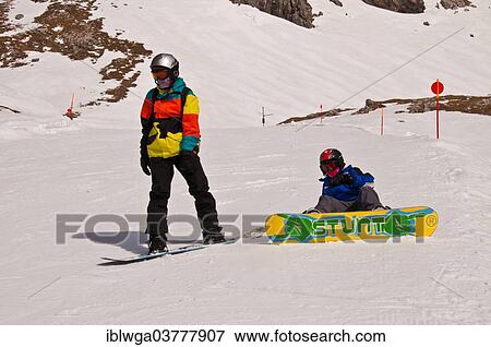 Stock Photo - "Two young snowboarders are preparing for a ski-run, Mt Nebelhorn, Oberstdorf, Allgau Alps, Upper Allgau, Bavaria, Germany, Europe". Fotosearch