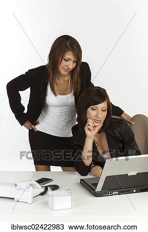 Stock Image - Two young women in an office. Fotosearch