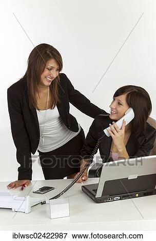 Two young women in an office View Large Photo Image Stock Photo - Two young women in an office. Fotosearch