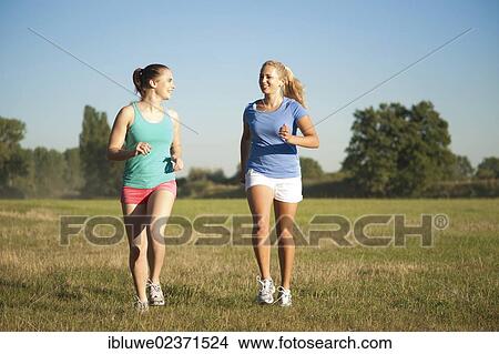 Two young women jogging outdoors View Large Photo Image Picture - Two young women jogging outdoors. Fotosearch