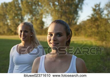 Stock Image - Two young women relaxing outdoors. Fotosearch