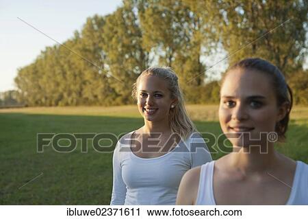 Two young women relaxing outdoors View Large Photo Image Stock Image - Two young women relaxing outdoors. Fotosearch