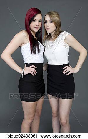 Two young women wearing white tops and short black skirts View Large Photo Image Stock Image - Two young women wearing white tops and short black skirts. Fotosearch