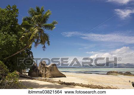 Picture - "Typical rock formations in the Seychelles with a sandy beach, Praslin island at the back, Anse Union, La Digue, Seychelles, Africa". Fotosearch