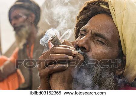 "Udaisin Sadhu, holy man, smoking marihuana at the Sangam, the confluence of the rivers Ganges, Yamuna and Saraswati, during Kumbha Mela festival, Allahabad, Uttar Pradesh, India, Asia" View Large Photo Image Stock Photography - "Udaisin Sadhu, holy man, smoking marihuana at the Sangam, the confluence of the rivers Ganges, Yamuna and Saraswati, during Kumbha Mela festival, Allahabad, Uttar Pradesh, India, Asia". Fotosearch