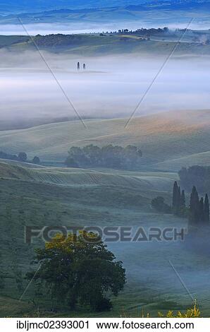 Stock Image - "Val d'Orcia, Orcia Valley at dawn, morning fog, UNESCO World Heritage Site, Siena Province, Tuscany, Italy, Europe". Fotosearch