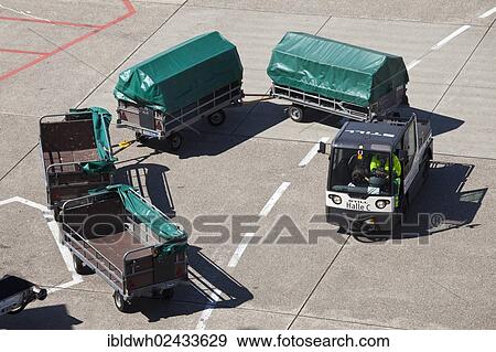 "Vehicle with trailers to transport luggage on the manoeuvring area, Duesseldorf International Airport, Duesseldorf, North Rhine-Westphalia, Germany, Europe" View Large Photo Image Stock Photo - "Vehicle with trailers to transport luggage on the manoeuvring area, Duesseldorf International Airport, Duesseldorf, North Rhine-Westphalia, Germany, Europe". Fotosearch