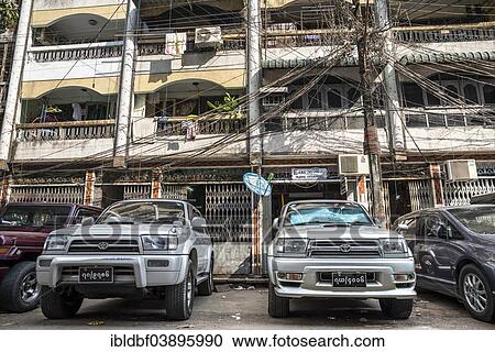 "Vehicles parked in front of a residential building, tangled cables, power lines, Yangon or Rangoon, Yangon Region, Myanmar, Asia" View Large Photo Image Stock Image - "Vehicles parked in front of a residential building, tangled cables, power lines, Yangon or Rangoon, Yangon Region, Myanmar, Asia". Fotosearch