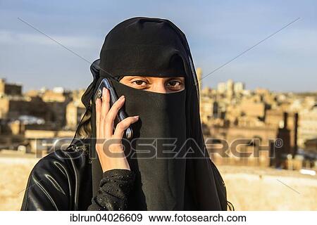 "Veiled young woman on her mobile, in the old city, Sana'a, Yemen, Asia" View Large Photo Image Stock Photo - "Veiled young woman on her mobile, in the old city, Sana'a, Yemen, Asia". Fotosearch