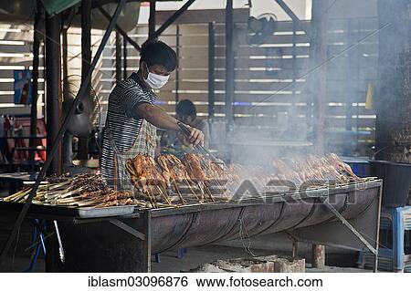 Stock Photograph - "Vendor grilling chicken, Chiang Mai, Chiang Mai Province, Thailand, Asia". Fotosearch