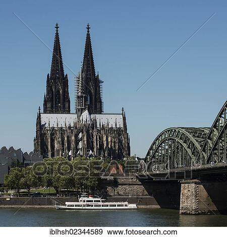 Stock Photo - "View as seen from Deutz across the Rhine river, Hohenzollernbruecke bridge, Willi Ostermann excursion boat in the foreground, Cologne Cathedral at the back, Cologne, North Rhine-Westphalia, Germany, Europe". Fotosearch