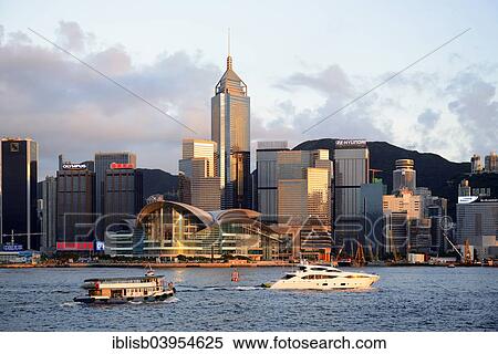 Stock Photography - "View from Kowloon on Hong Kong Island's skyline on Hong Kong River, with boats on the river, Central, with the International Conference Centre, in the evening light, Hong Kong, China, Asia". Fotosearch