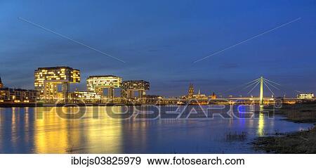 Stock Photo - "View from the Pollerwiesen meadows over the Rhine River with Rheinauhafen and the Crane Houses, Severin Bridge and Cologne Cathedral at the blue hour, Cologne, North Rhine-Westphalia, Germany, Europe". Fotosearch