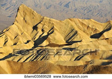 Stock Photo - "View from Zabriskie Point over the eroded rock formations of Manly Beacon discoloured by minerals, Panamint Range at the rear, in the morning light, Death Valley National Park, Mojave Desert, California, United States, North America". Fotosearch