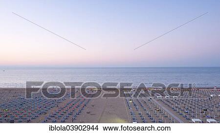 Picture - "View of a beach with sunshades and sun beds, twilight, 6 am, image 2 of 9, Lignano Sabbiadoro, Udine province, Adriatic Coast, Italy, Europe". Fotosearch