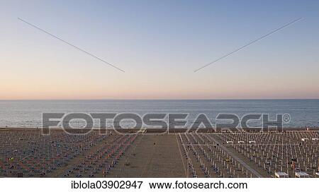 Stock Photo - "View of a beach with sunshades and sun beds, 7 am, image 3 of 9, Lignano Sabbiadoro, Udine province, Adriatic Coast, Italy, Europe". Fotosearch