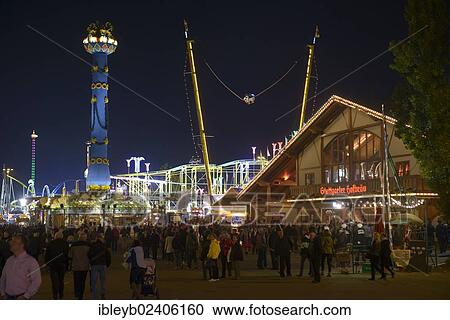 Stock Image - "View of the Cannstatter Volksfest fair, rides, funfair, beer tents, people with the Fruit column, Stuttgart, Baden-Wuerttemberg, Germany, Europe". Fotosearch