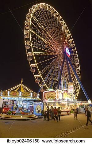 Stock Photo - "View of the Cannstatter Volksfest fair, a Ferris wheel on the east entrance and a carousel in the foreground, Stuttgart, Baden-Wuerttemberg, Germany, Europe". Fotosearch