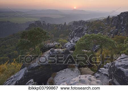 "View of the Schrammsteine ​​in the Elbe Sandstone Mountains at sunset in autumn, Saxon Switzerland, Bad Schandau, Saxony, Germany, Europe" View Large Photo Image Stock Photo - "View of the Schrammsteine ​​in the Elbe Sandstone Mountains at sunset in autumn, Saxon Switzerland, Bad Schandau, Saxony, Germany, Europe". Fotosearch