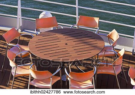 "View over a deck with a table and chairs on a cruise ship in the port of Izmir, Turkey, Asia" View Large Photo Image Stock Photograph - "View over a deck with a table and chairs on a cruise ship in the port of Izmir, Turkey, Asia". Fotosearch