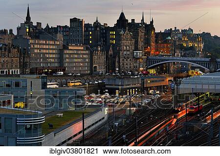 Stock Image - "View over railway station on old town at dusk, Edinburgh, Scotland, United Kingdom, Europe". Fotosearch