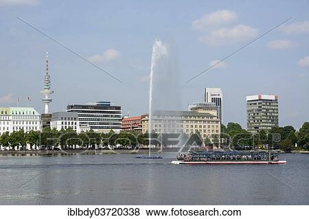 Stock Photo - "View over the Inner Alster Lake with Alster Fountain and an Alster excursion boat towards the street of Neuer Jungfernstieg, Hotel Vier Jahreszeiten or Four Seasons Hotel and the television tower at the rear, Hamburg, Hamburg, Germany, Europe". Fotosearch