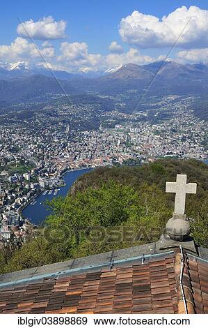 Stock Photo - "View over the roof of a chapel onto Lugano, Lake Lugano and the Alps, Monte San Salvatore mountain, Lugano, Canton of Ticino, Switzerland, Europe". Fotosearch