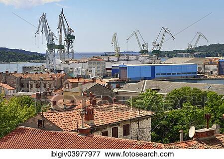"View over the rooftops of the city on the loading cranes in the port, Pula, Istria, Croatia, Europe" View Large Photo Image Stock Photo - "View over the rooftops of the city on the loading cranes in the port, Pula, Istria, Croatia, Europe". Fotosearch