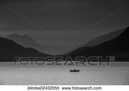 "View over Weissensee lake towards Techendorf in the evening light, with a fisherman in a rowboat at the front, Weissensee lake, Carinthia, Austria, Europe" View Large Photo Image Stock Photography - "View over Weissensee lake towards Techendorf in the evening light, with a fisherman in a rowboat at the front, Weissensee lake, Carinthia, Austria, Europe". Fotosearch