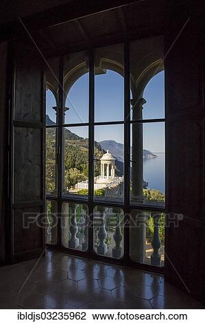 Stock Image - "View through arched windows of the park and the coastline, Son Marroig, Deia, Majorca, Balearic Islands, Spain, Europe". Fotosearch