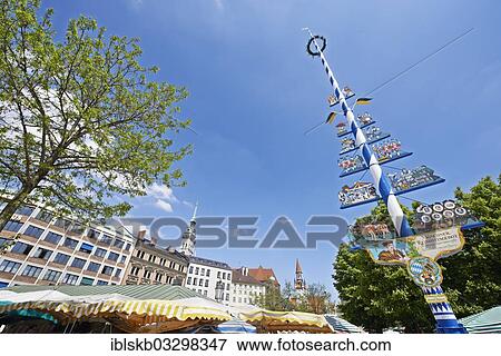 Stock Photo - "Viktualienmarkt square with a maypole and the colourful umbrellas of the market stalls, St. Peter's Church and the Old Town Hall tower at the rear, city centre, Munich, Upper Bavaria, Bavaria, Germany, Europe". Fotosearch