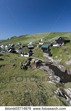 Stock Photo - "Village with houses mostly in the traditional Faroese style, wood on a stone base with a sod roof, Mykines, Mykines, Faroe Islands, Denmark, Europe". Fotosearch