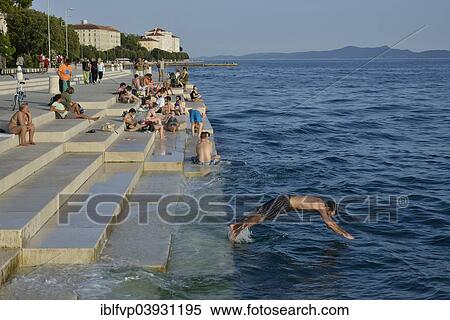 "Visitors basking in the evening sun at the Sea Organ by architect Nikola Basic, Zadar, Dalmatia, Croatia, Europe" View Large Photo Image Stock Photography - "Visitors basking in the evening sun at the Sea Organ by architect Nikola Basic, Zadar, Dalmatia, Croatia, Europe". Fotosearch