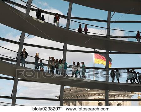 Stock Image - "Visitors in the dome of the Reichstag Building and the German national flag, Berlin, Germany, Europe". Fotosearch