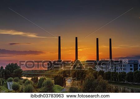 "VW KonzernForum premises with the entrance to the Autostadt complex and the heating station of the Volkswagen plant with its four chimneys, Wolfsburg, Lower Saxony, Germany, Europe" View Large Photo Image Stock Image - "VW KonzernForum premises with the entrance to the Autostadt complex and the heating station of the Volkswagen plant with its four chimneys, Wolfsburg, Lower Saxony, Germany, Europe". Fotosearch