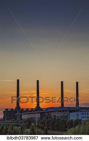 "VW KonzernForum premises with the entrance to the Autostadt complex and the heating station of the Volkswagen plant with its four chimneys, Wolfsburg, Lower Saxony, Germany, Europe" View Large Photo Image Stock Photo - "VW KonzernForum premises with the entrance to the Autostadt complex and the heating station of the Volkswagen plant with its four chimneys, Wolfsburg, Lower Saxony, Germany, Europe". Fotosearch